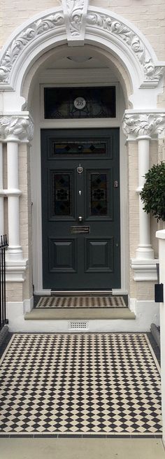 a black and white checkered floor in front of a building with a large door