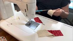 a woman is using a sewing machine to sew on some pieces of cloths