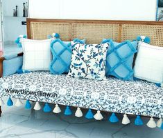 a couch with blue and white pillows on it