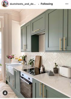 an image of a kitchen setting with green cabinets and marble counter tops on instagram