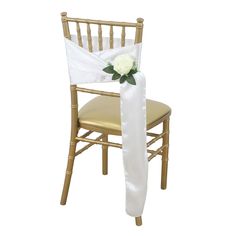 a chair with a white flower on it and a satin sash draped over the seat