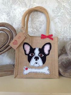 a small bag with a dog's face on it and a red bow around the neck