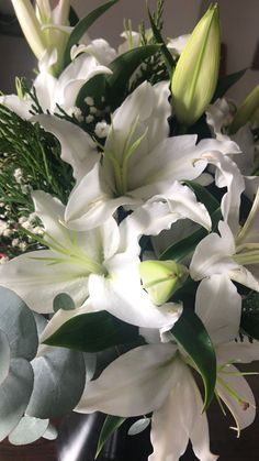 a vase filled with white flowers on top of a table