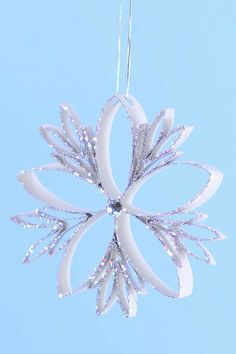 a white snowflake ornament hanging from a string on a blue background