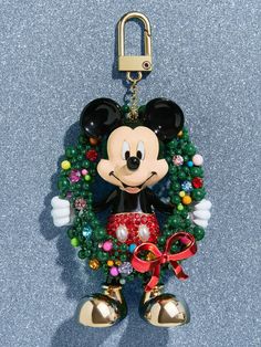 a mickey mouse ornament hanging from a keychain with bells around it