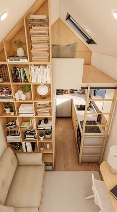 an aerial view of a living room with bookshelf and kitchen in the background