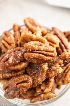 a glass bowl filled with pecans on top of a table