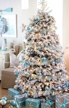 a flocked Christmas tree with lights, silver and tiffany blue ornaments, snowy pinecones and starfish is a fresh idea for a beach Christmas space Blue And White Christmas, Coastal Christmas Tree, Happy Christmas Eve, Coastal Christmas Decor, Beachy Christmas, Gold Christmas Decorations