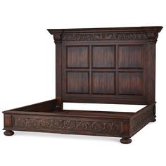 a wooden bed frame with intricate carvings on the headboard