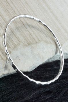 This sterling silver bangle bracelet was made by Navajo silversmith Elaine Tahe.Circumference: 8"Width: 1/8"Free shipping on all orders! We ship with USPS and always include tracking. All orders ship within a day of payment.Returns are accepted up to 30 days after you receive your order. Just send us a message. Our shop offers cash back or store credit. The item must be returned in new condition. Sterling Silver Stackable Round Bracelet, Stackable Sterling Silver Bracelet, Stackable Round Sterling Silver Bracelet, Sterling Silver Stackable Bangle, Sterling Silver Stackable Round Bangle, Stackable Sterling Silver Bangle, Hammered Sterling Silver Round Bracelets, Hammered Sterling Silver Round Bangle, Sterling Silver Hammered Bracelets