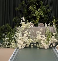 the table is surrounded by white flowers and greenery