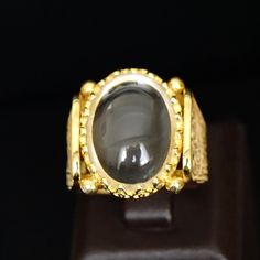 Capture a beautiful moment with this 18K yellow gold plated sterling silver crystal quartz ring. Handmade with natural Durr Al Najaf gemstone, this unique jewelry is a daring addition to your collection. Size 10, but can be resized. Metal: 925k Sterling Silver (18k gold plated) Gemstone: Crystal Quartz also known as Durr al-Najaf Dimensions of the stone: 15x20mm Size: US 10 Durr Al Najaf is a glossy and clear gemstone from the quartz family. The name means "pearl of Najaf" as it can only be sour Luxury Yellow Gold Crystal Ring With Gemstone, Elegant Gold Moonstone Cabochon Ring, Spiritual Yellow Gold Crystal Ring, Luxury Gold-plated Crystal Ring, Spiritual Gold Moonstone Cabochon Ring, Elegant Gold Hallmarked Crystal Ring, Luxury Gold Oval Moonstone Ring, Handmade Elegant Gold Moonstone Ring, Luxury Citrine Cabochon Jewelry