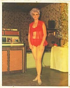 an old photo of a woman standing in front of a radio