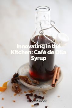 an image of a glass bottle filled with liquid and cinnamon sticks on a plate next to it