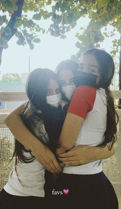 three girls hugging each other in the park