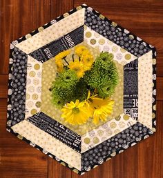 a patchwork hexagon with yellow flowers in it on a wood flooring surface