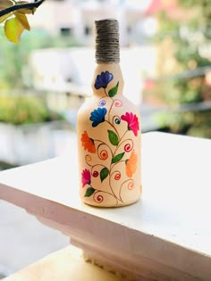 a bottle that is sitting on top of a table with a tree in the background