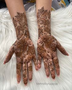 two hands with henna designs on them