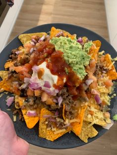 a plate filled with nachos and guacamole on top of it