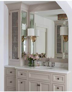 a bathroom with two sinks and large mirrors on the wall above it is decorated in white