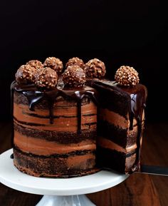 a chocolate cake on a white plate with three pieces cut out