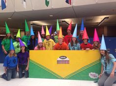 a group of people wearing party hats posing in front of a sign with the words happy birthday written on it