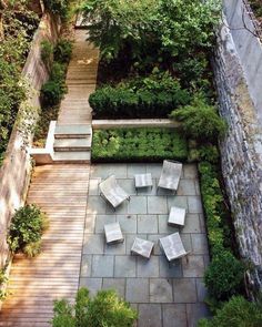 an aerial view of a small garden with seating and steps leading up to the top