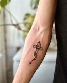 a person with a cross tattoo on their arm