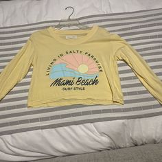 Reposhing This Item I Purchased From @Lolli_posh. Loved It, But Ready To Rotate For Something New. Cute But Never Worn, Did Wash Once, Great Condition. Cute Little Miami Beach Long Sleeve Shirt. Questions? Leave A Comment Below! Yellow T-shirt For Spring Vacation, Casual Yellow T-shirt For Vacation, Trendy Long Sleeve T-shirt For Beach, Beachy Long Sleeve Tops For Beach Season, Graphic Print Long Sleeve Tops For Beach Season, Long Sleeve Graphic Print Tops For Beach Season, Yellow Beachy Top For Vacation, Long Sleeve T-shirt For Spring Vacation, Beachy Crew Neck Spring Tops