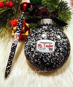 a black and white christmas ornament next to a pen