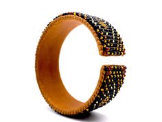 "Made using genuine Guatemalan leather and exquisite glass beads, this cuff bracelet gives off an elegant and luxurious feel. Its unique patterns are brilliantly colored with strong Native American influences. Every piece in our collection is hand stitched with impeccable precision and detail. They are designed to make you feel bold and empowered! Flexible cuff fits all-sized adult wrists Band width measures approximately 3/4\" Handmade in Guatemala *Please note that all of our items are handcra Leather Beaded Bracelets With Round Beads For Gift, Leather Bracelets With Round Beaded Details, Handmade Leather Beaded Bracelets, Brown Beaded Cuff Bracelet Bangle, Brown Beaded Bangle Cuff Bracelet, Brown Beaded Cuff Bracelet, Elegant Leather Beaded Bracelets, Elegant Beaded Leather Bracelets, Leather Bracelet With Round Beaded Details