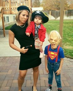 a woman and two children dressed up as the same person in halloween costumes, posing for a photo