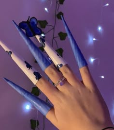 a woman's hand with blue and white nail polish holding up some fake toothbrushes