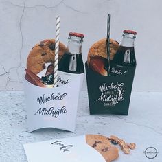 two bottles of milk and cookies sitting next to each other