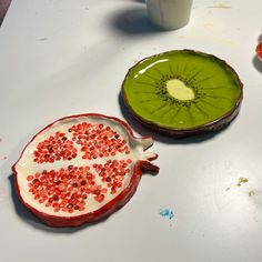 two pieces of fruit sitting on top of a table