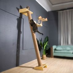 a cat climbing on a wooden pole in a living room