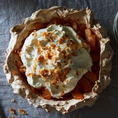 a pie topped with whipped cream and toppings on top of a blue table cloth