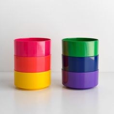 three different colored cups sitting next to each other