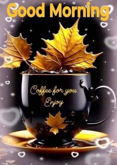 a coffee cup with some leaves on it and the words good morning written in gold