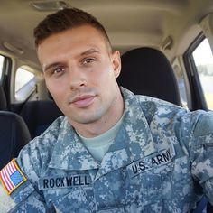 a man in uniform sitting in the back seat of a car