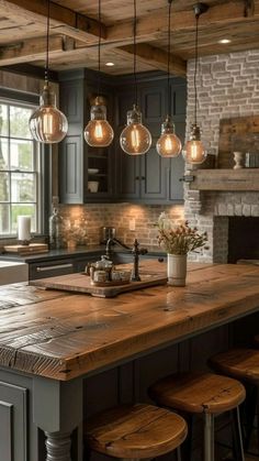 a kitchen island with lights hanging from it's ceiling and stools around it