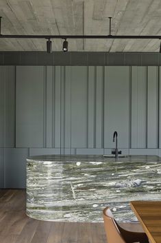 a large kitchen with an island counter and wooden flooring, along with gray cabinets