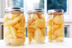 two jars filled with sliced apples on top of a table