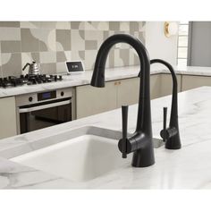 a black faucet in a kitchen with marble counter tops