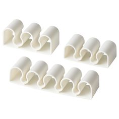 four white plastic pipe holders on a white background