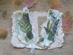 some cards are laying on a doily with leaves