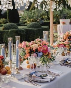 the table is set with flowers, candles and plates for an elegant dinner or party