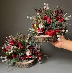 two baskets with christmas decorations on them are shown in front of a hand holding one