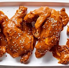 chicken wings covered in sesame seeds on a white plate