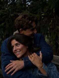 two people hugging each other on a bench